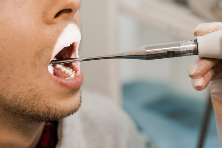 Ultrasound treatment of tonsillitis in the throat. ENT doctor conducts ultrasound machine treatment to patient in medical clinic